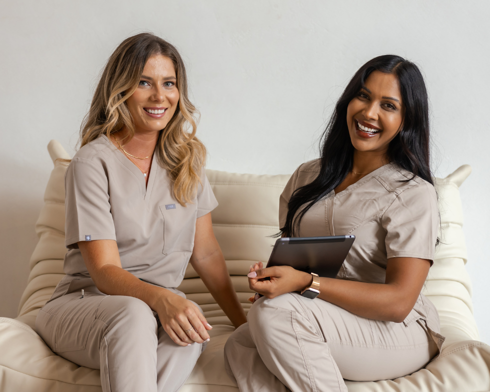 Fresh Clinics Cosmetic Clinic Compliance - two people sitting on a coach, smiling at the camera.